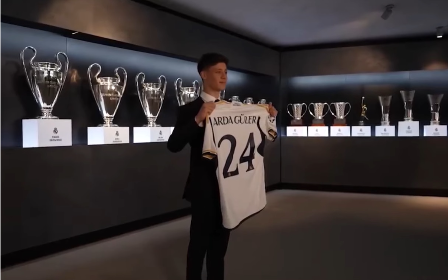 Arda Guler segurando uma camisa do Real Madrid com transferência bem-sucedida